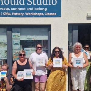 People displaying artworks outside Make & Mould Studio.